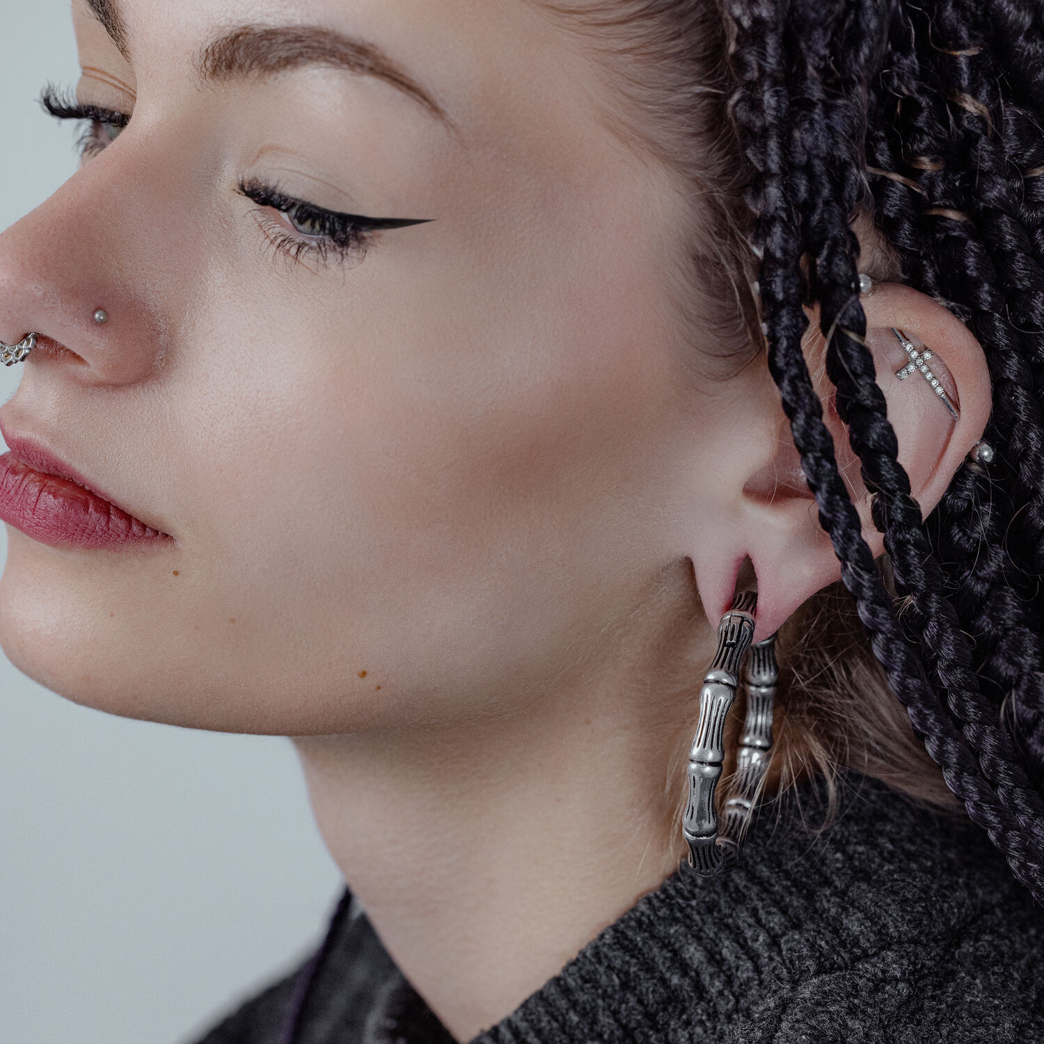 Poids d'oreille Bonechain en acier chirurgical Femme aux cheveux noirs tressés portant un poids d'oreille Bonechain argenté à l'oreille
