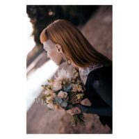 Poids d'oreille tressés en acier chirurgical Personne avec des poids d'oreille tressés et un bouquet de fleurs au bord du lac