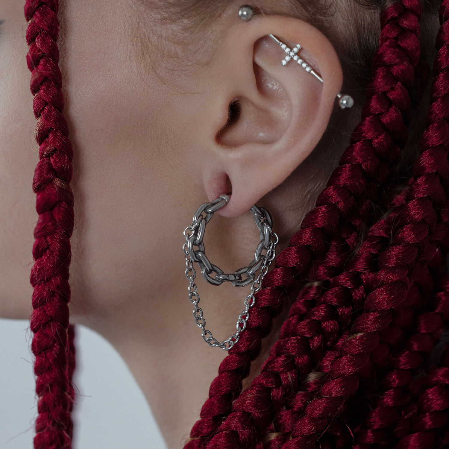 Poids d'oreilles à double chaîne en argent Poids d'oreille à double chaîne en argent sur une oreille avec des tresses rouges