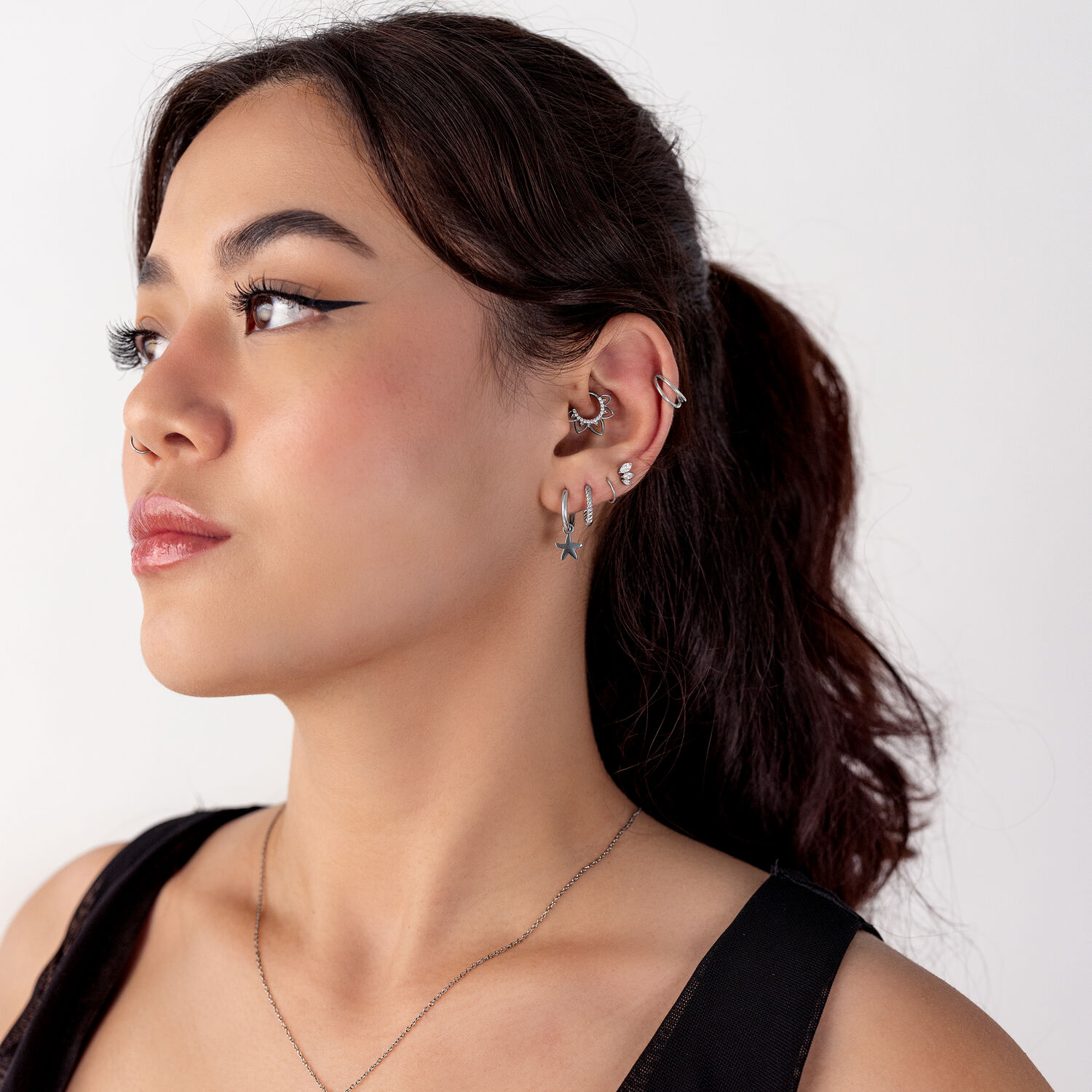 Clicker Septum Flower Lines Argenté Femme avec plusieurs piercings d'oreille en argent, profil latéral
