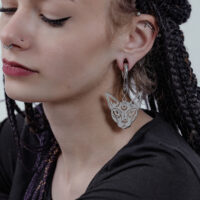 Poids d'oreille Sphynx en acier chirurgical Femme aux cheveux tressés portant un poids d'oreille Sphynx en argent.