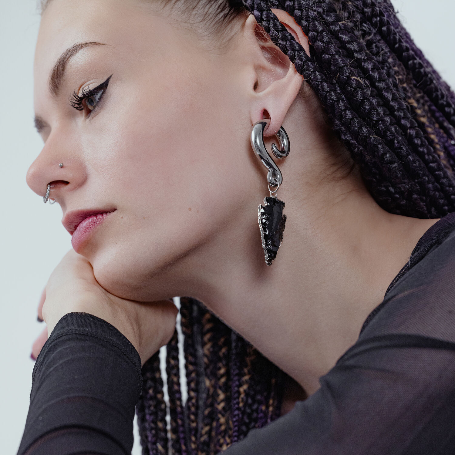 Femme avec poids d'oreille pendants en obsidienne argentée, profil latéral