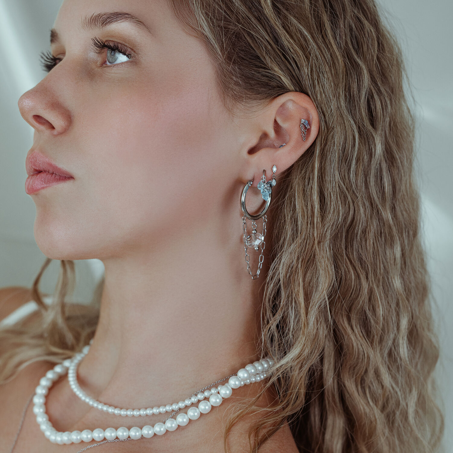 Élégantes boucles d'oreilles avec cristaux en argent Femme avec piercings d'oreilles en argent et cristaux, gros plan