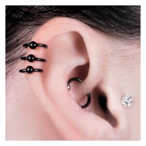 Oreille avec clous d'oreilles noirs en acier chirurgical et petit cristal