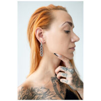 Petites créoles épaisses en argent à l'oreille Boucles d'oreilles en argent au design de chaîne portées à une oreille avec une main tatouée et des cheveux rouges
