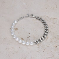 Bracelet avec perles blanches et chaîne argentée sur pierre claire