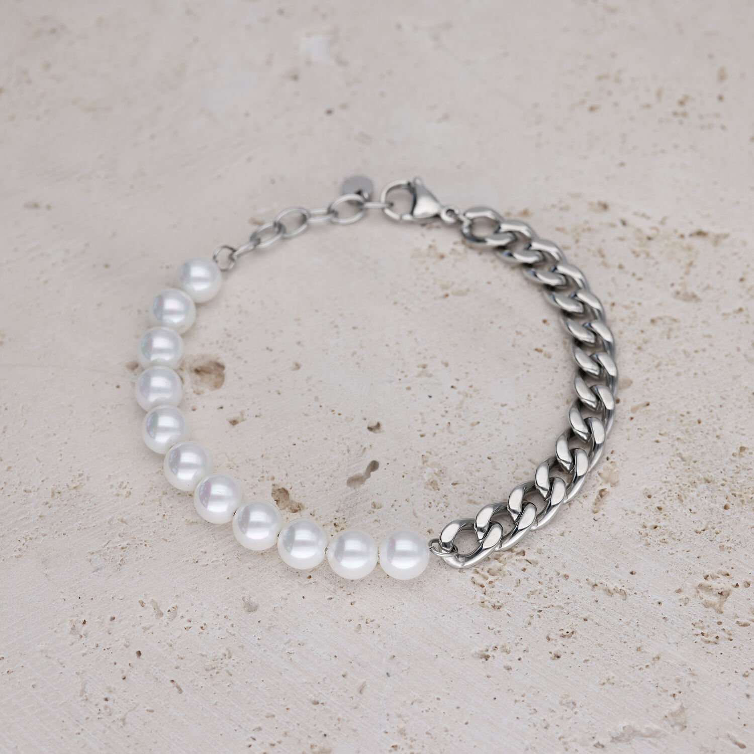 Bracelet avec perles blanches et chaîne argentée sur pierre claire