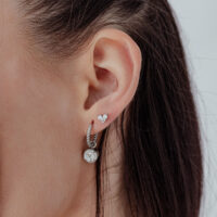 Embout en forme de cœur argenté avec cristal pour oreille Embout en forme de cœur argenté avec pierre cristalline à l'oreille, vue latérale