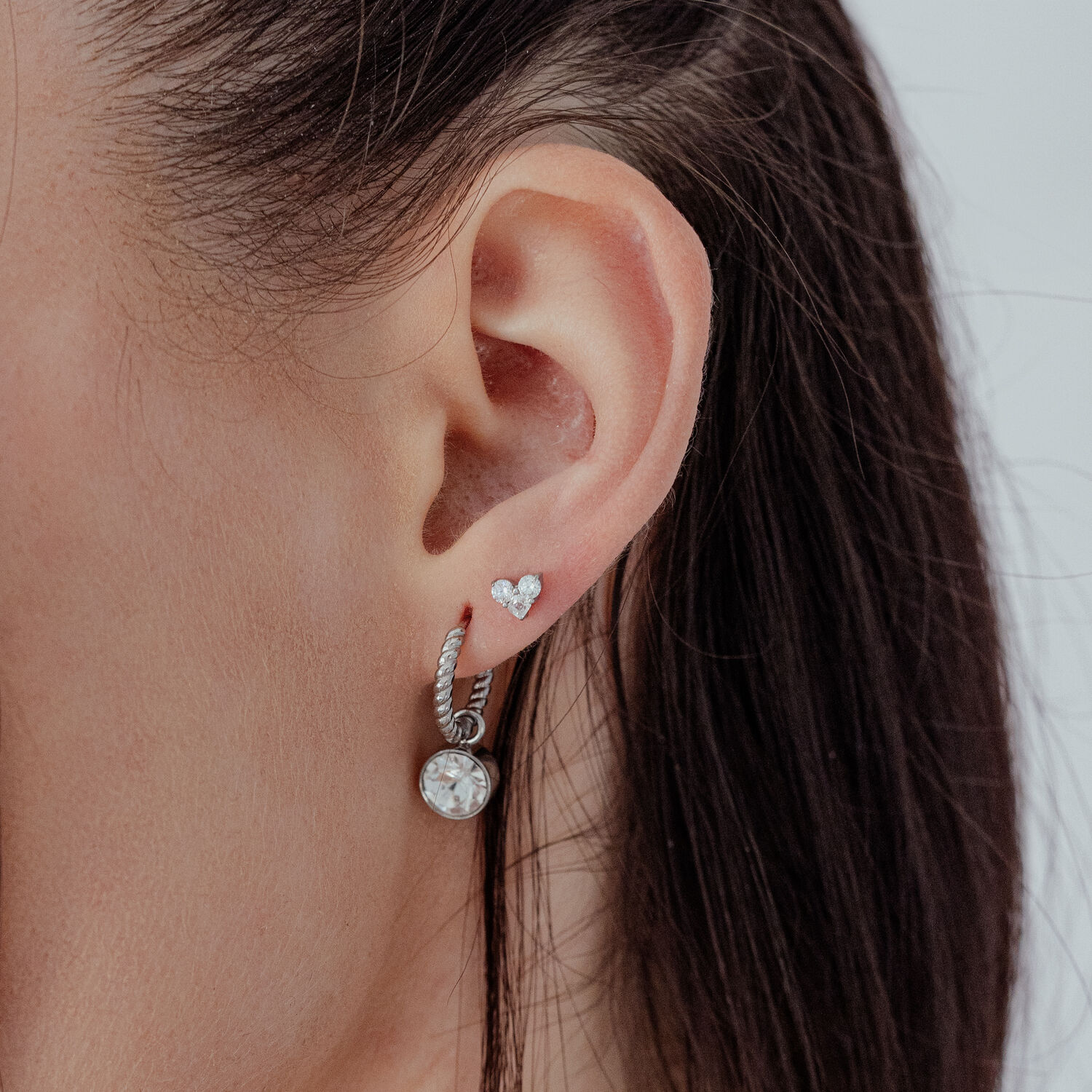 Embout en forme de cœur argenté avec cristal pour oreille Embout en forme de cœur argenté avec pierre cristalline à l'oreille, vue latérale