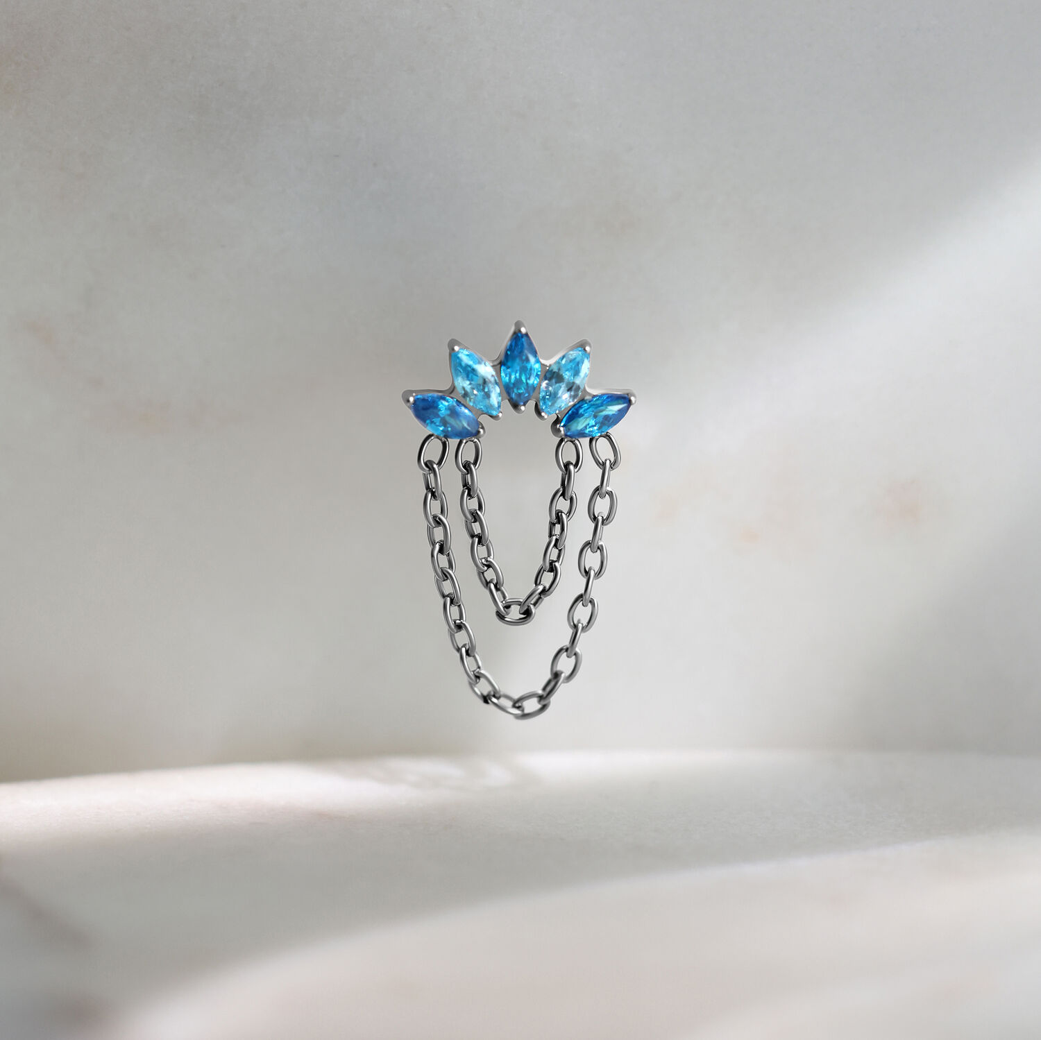 Push Fit embout argenté avec cristaux turquoise Embout de piercing Push Fit argenté avec trois cristaux turquoise sur fond clair