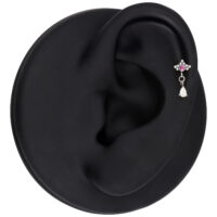 Piercing d'oreille argenté avec cristal rouge Piercing d'oreille argenté avec cristal rouge et pendentif ovale, présenté sur un modèle d'oreille noir.