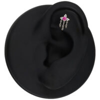 Clou d'oreille en argent avec cristaux rouges Clou d'oreille en argent avec cristal rouge et chaînes sur une oreille modèle noire