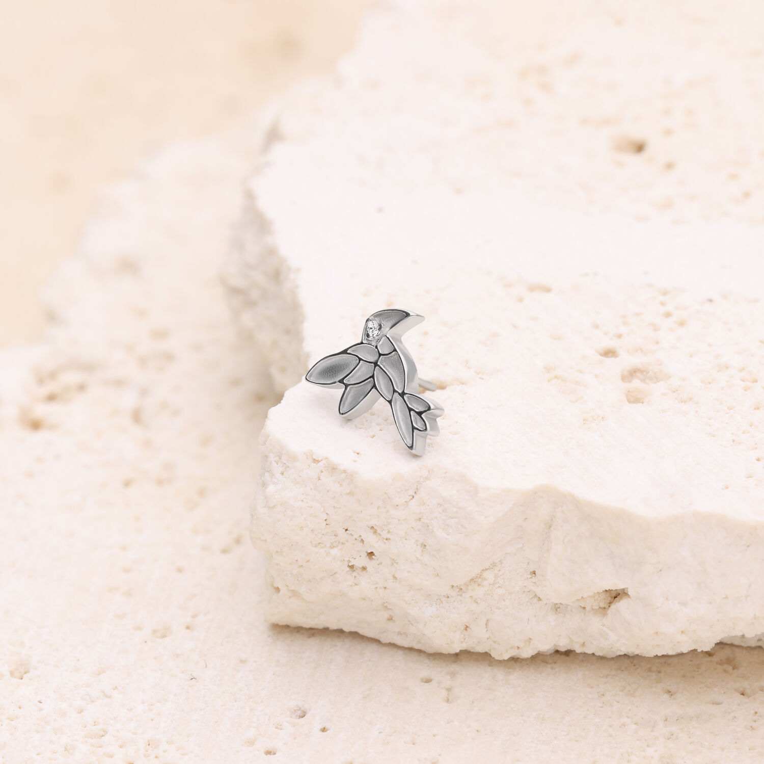 Embout de piercing colibri en or blanc Embout colibri en or blanc placé sur une pierre claire