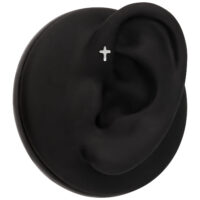 Modèle d'oreille noir avec piercing croix argenté sur fond noir