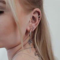 Embout Étoile en Cristal Push Fit à l'Oreille Gros plan d'une oreille avec plusieurs piercings, dont un grand embout étoile en cristal argenté Push Fit.