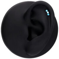 Embout Push Fit argenté avec trois cristaux étincelants en lavande et turquoise sur un modèle d'oreille noir