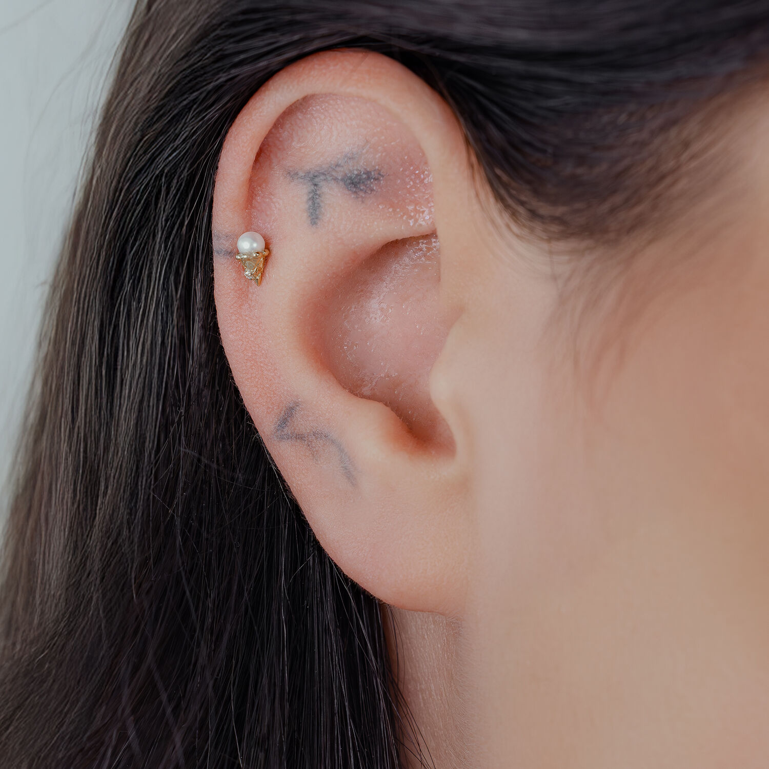 Embout Push Fit en Titane Doré pour l'Oreille Embout Push Fit en Titane Doré avec cristal clair porté à l'oreille.
