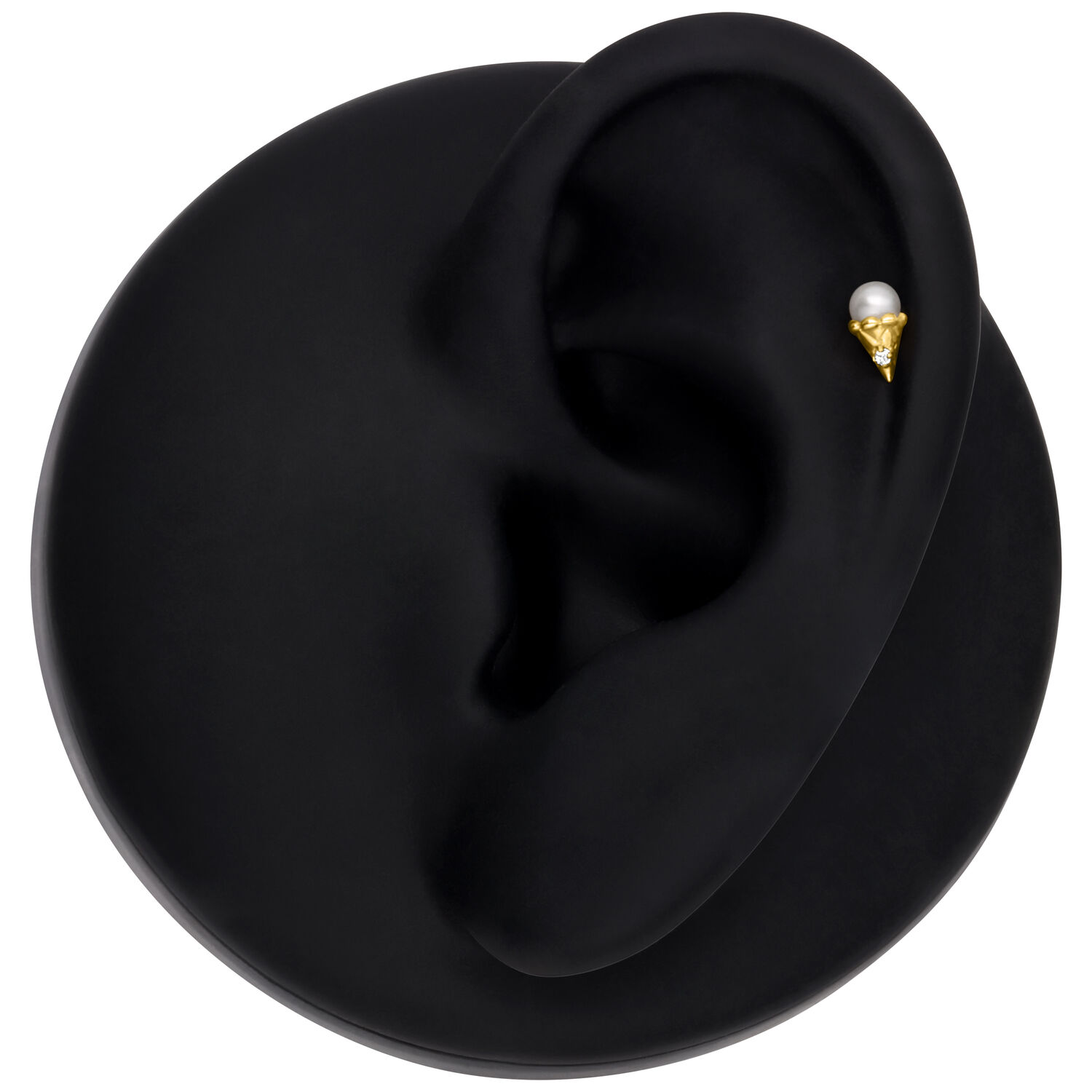 Embout Push Fit doré avec cristal Embout Push Fit doré placé sur un modèle d'oreille noir