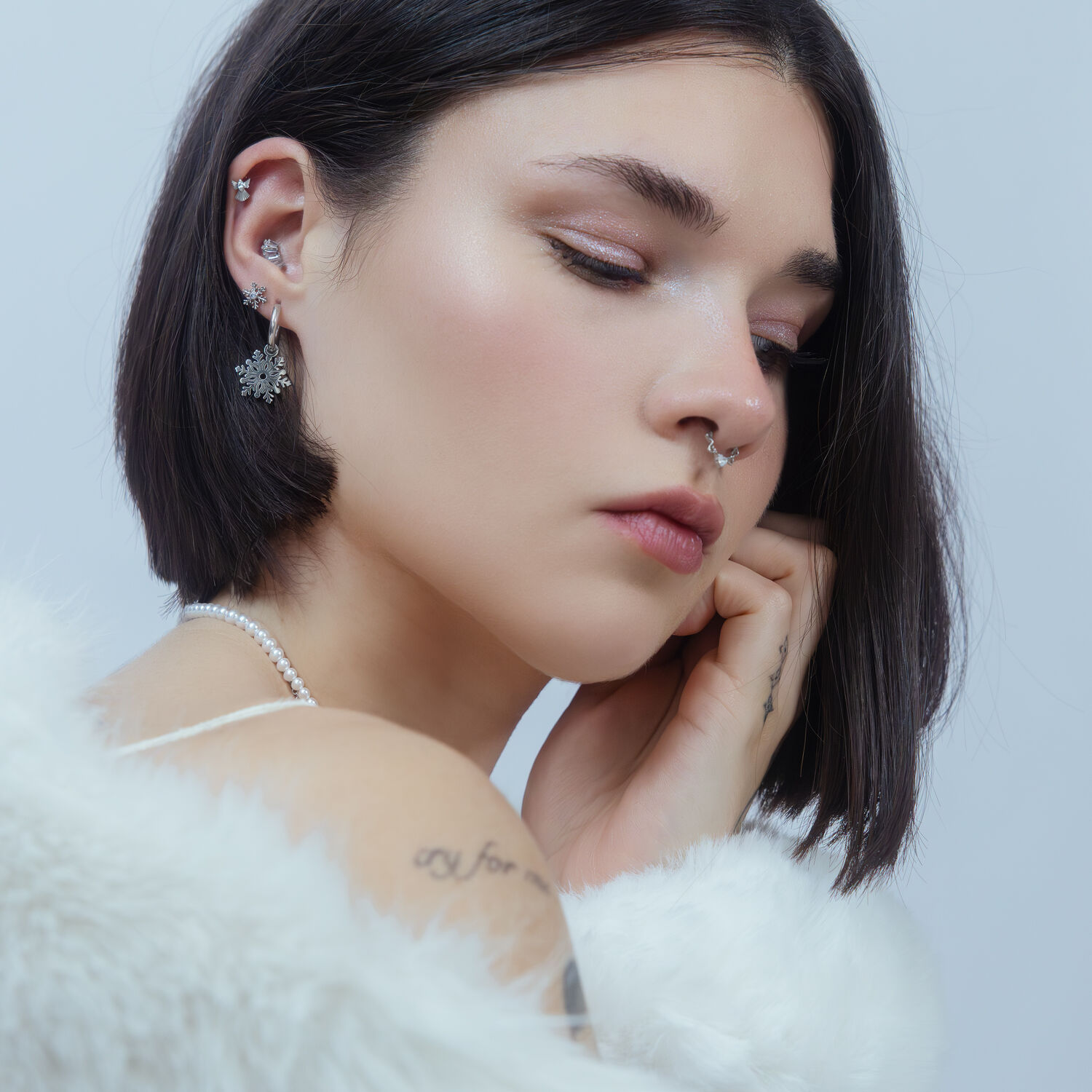 Embout Flocon de Neige Push Fit en Argent Femme avec piercing flocon de neige en argent à l'oreille devant un fond clair