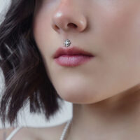 Embout de piercing en cristal pour Push Fit Gros plan sur un embout de piercing en cristal argenté sur le piercing Medusa d'une femme sur fond neutre