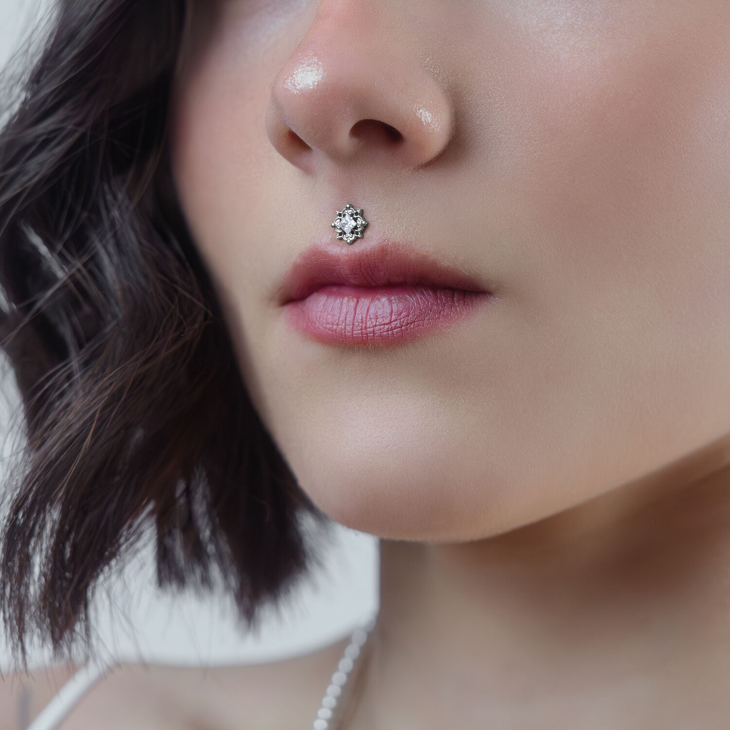 Embout de piercing en cristal pour Push Fit Gros plan sur un embout de piercing en cristal argenté sur le piercing Medusa d'une femme sur fond neutre