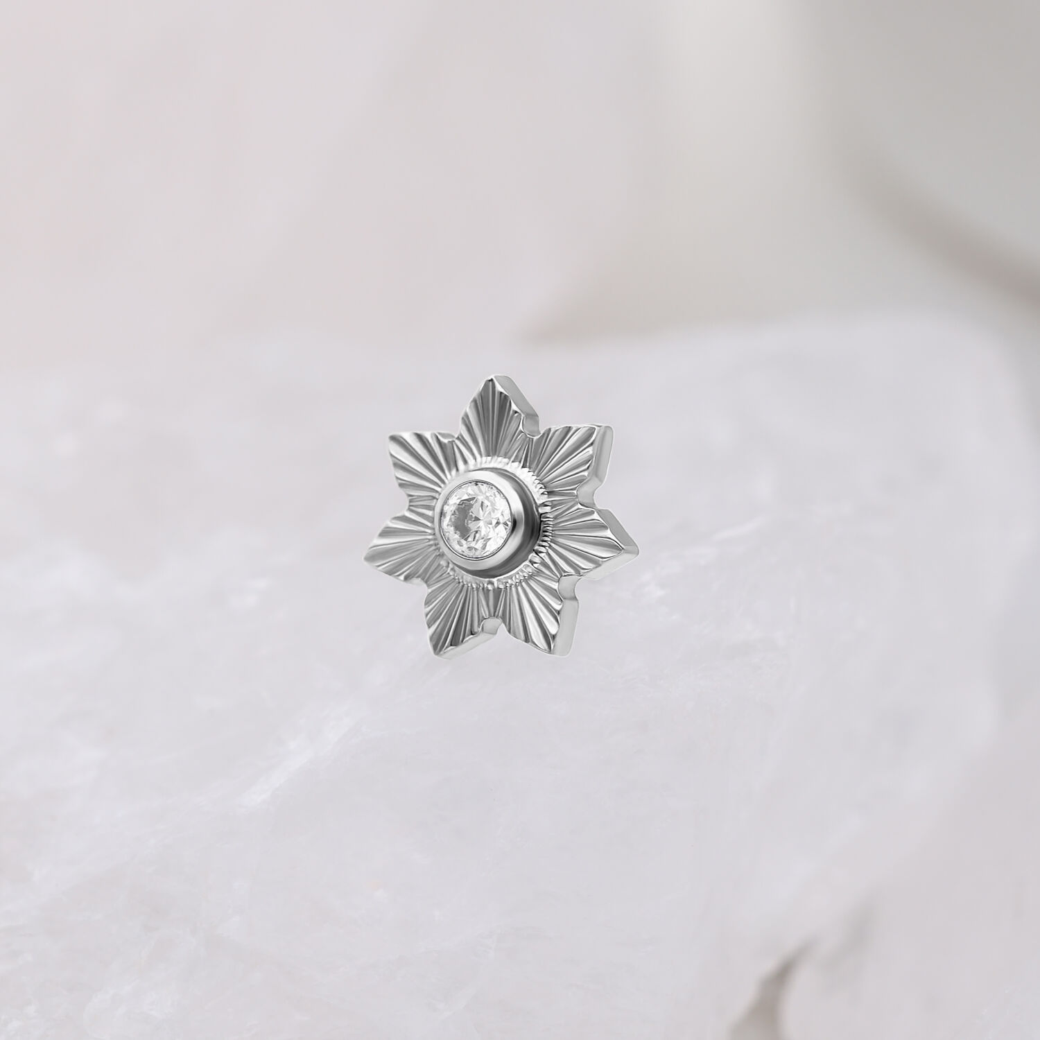 Embout Push Fit argenté avec cristal Embout Push Fit argenté en forme d'étoile avec cristal clair sur fond blanc