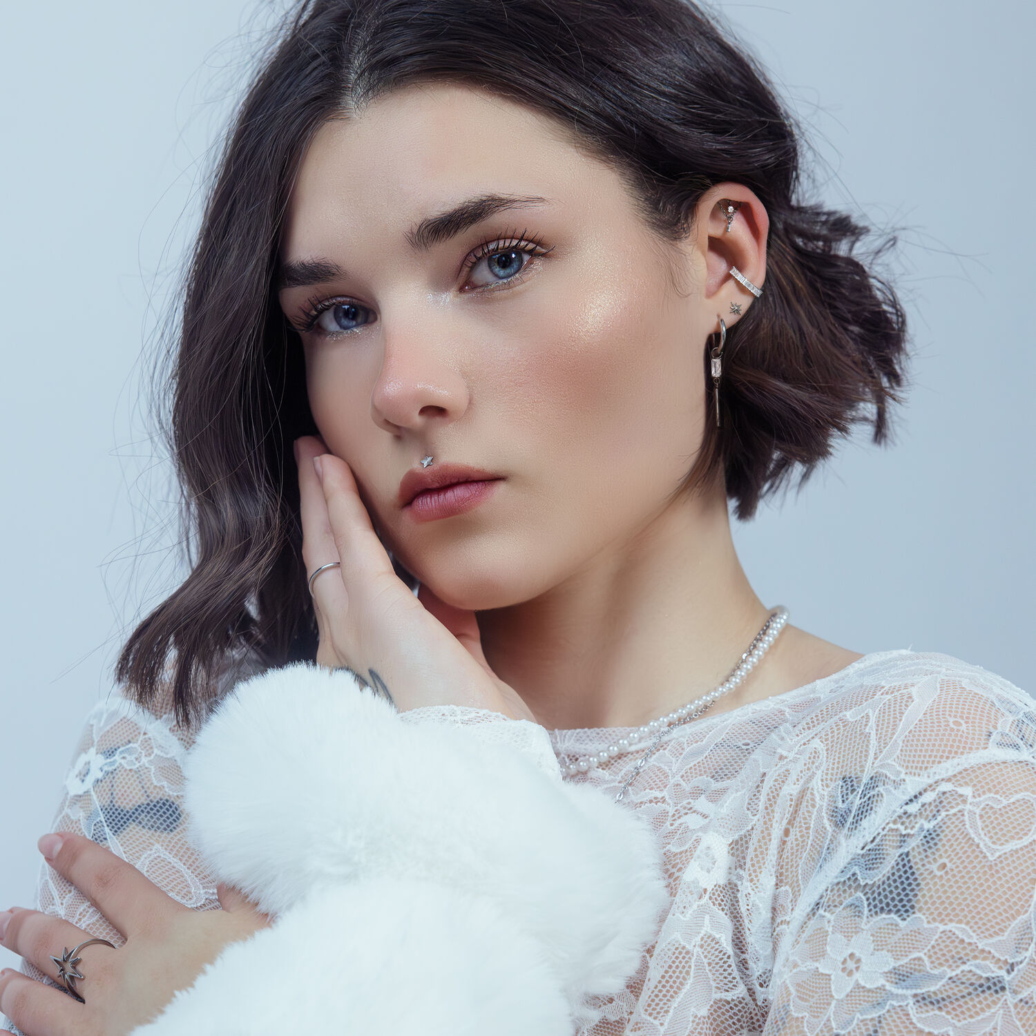 Femme aux cheveux courts portant un embout étoile argenté Push Fit à l'oreille, sur fond blanc