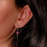 Embout d'oreille argenté avec cristaux rouges Embout d'oreille argenté avec cristaux rouges en forme de baguette sur l'oreille d'une personne