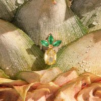Embout de piercing ananas doré avec feuilles vertes Embout de piercing ananas doré avec trois feuilles vertes sur une peau d'ananas
