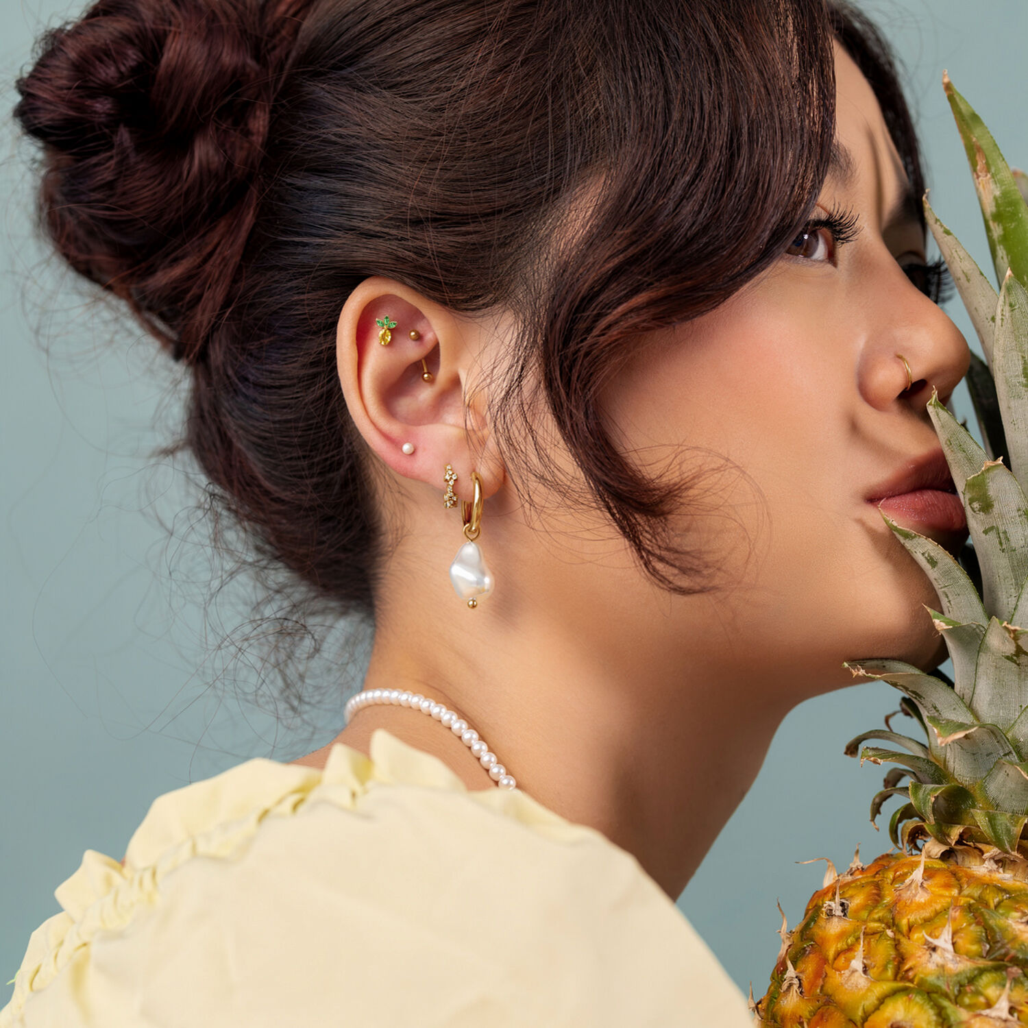 Embout Push Fit Ananas Doré Femme avec des boucles d'oreilles dorées et un embout ananas, profil latéral