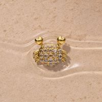 Embout Crabe Push Fit Doré Embout crabe doré avec strass sur fond sableux