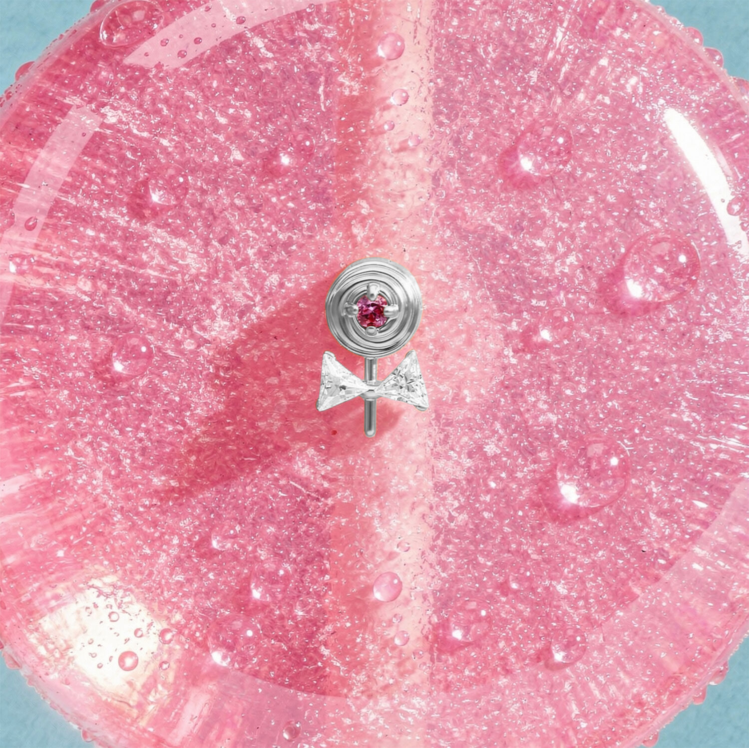 Embout de piercing Lollipop argenté Embout Lollipop argenté avec pierre rose sur fond rose scintillant