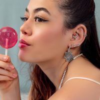 Piercings d'oreille argentés avec Lollipop Femme avec plusieurs piercings d'oreille argentés et un Lollipop rose, de côté
