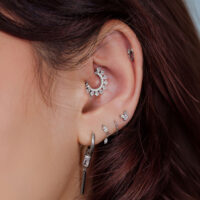 Embouts de piercing en titane argentés pour l'oreille Gros plan d'une oreille avec plusieurs embouts de piercing argentés et bijoux.