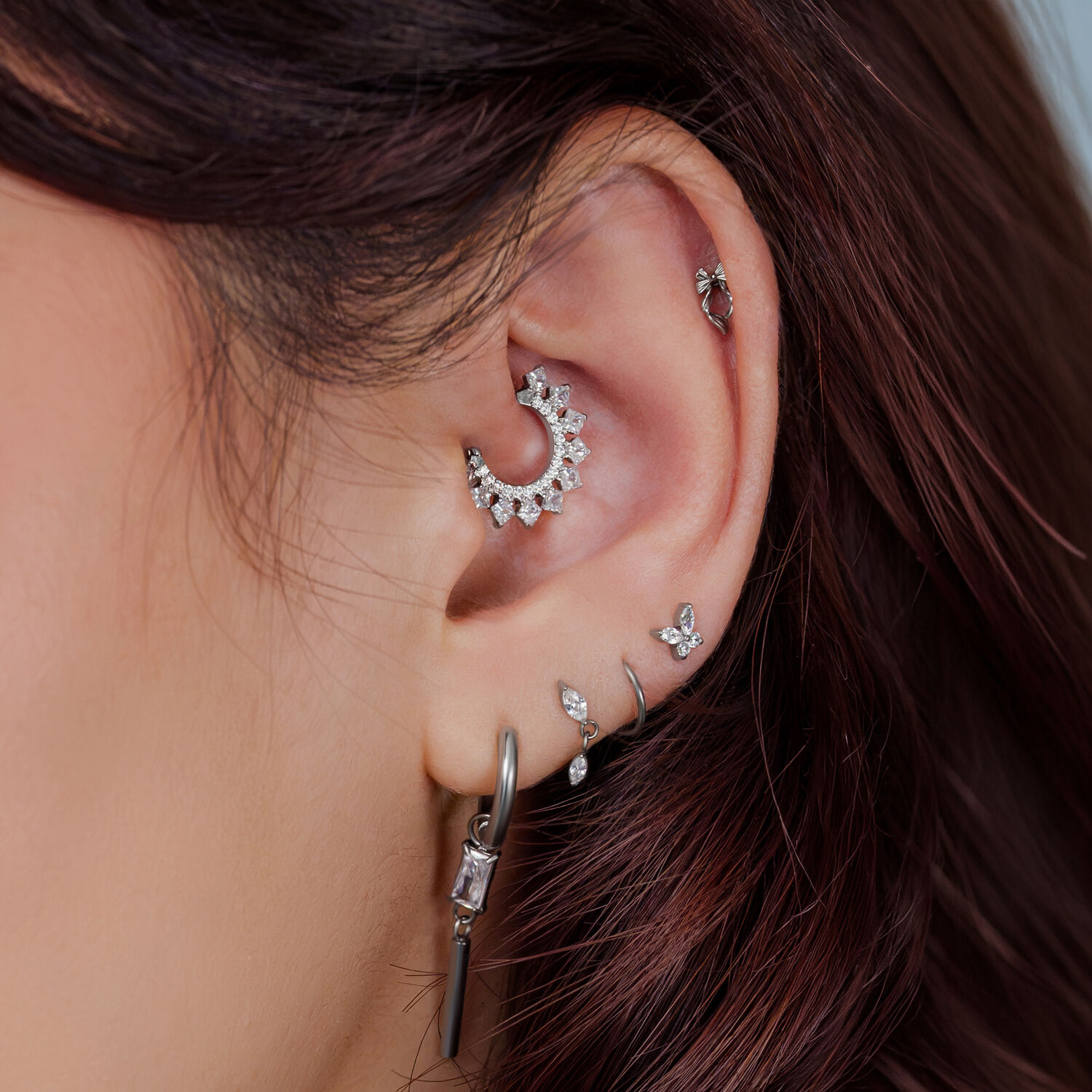 Embouts de piercing en titane argentés pour l'oreille Gros plan d'une oreille avec plusieurs embouts de piercing argentés et bijoux.