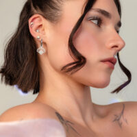 Femme aux cheveux courts portant un embout ovale en opale argenté à l'oreille