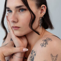 Embout Helix argenté avec design Oval Drop Femme avec plusieurs piercings d'oreille, dont un embout Helix argenté, gros plan