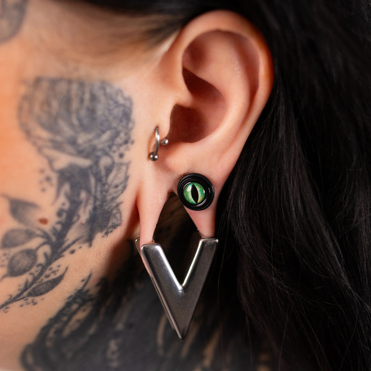 Verena Venus faux plug paire portée à l'oreille Faux plug paire en PMMA noir avec détail vert porté à l'oreille