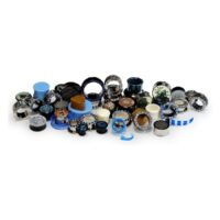 Ensemble de piercings colorés en acrylique et acier Différents piercings en acrylique, silicone et acier chirurgical sur fond blanc