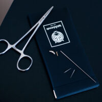 Kit de changement de piercing avec outil Kit de piercing avec pince, aiguilles et petites pièces sur fond noir