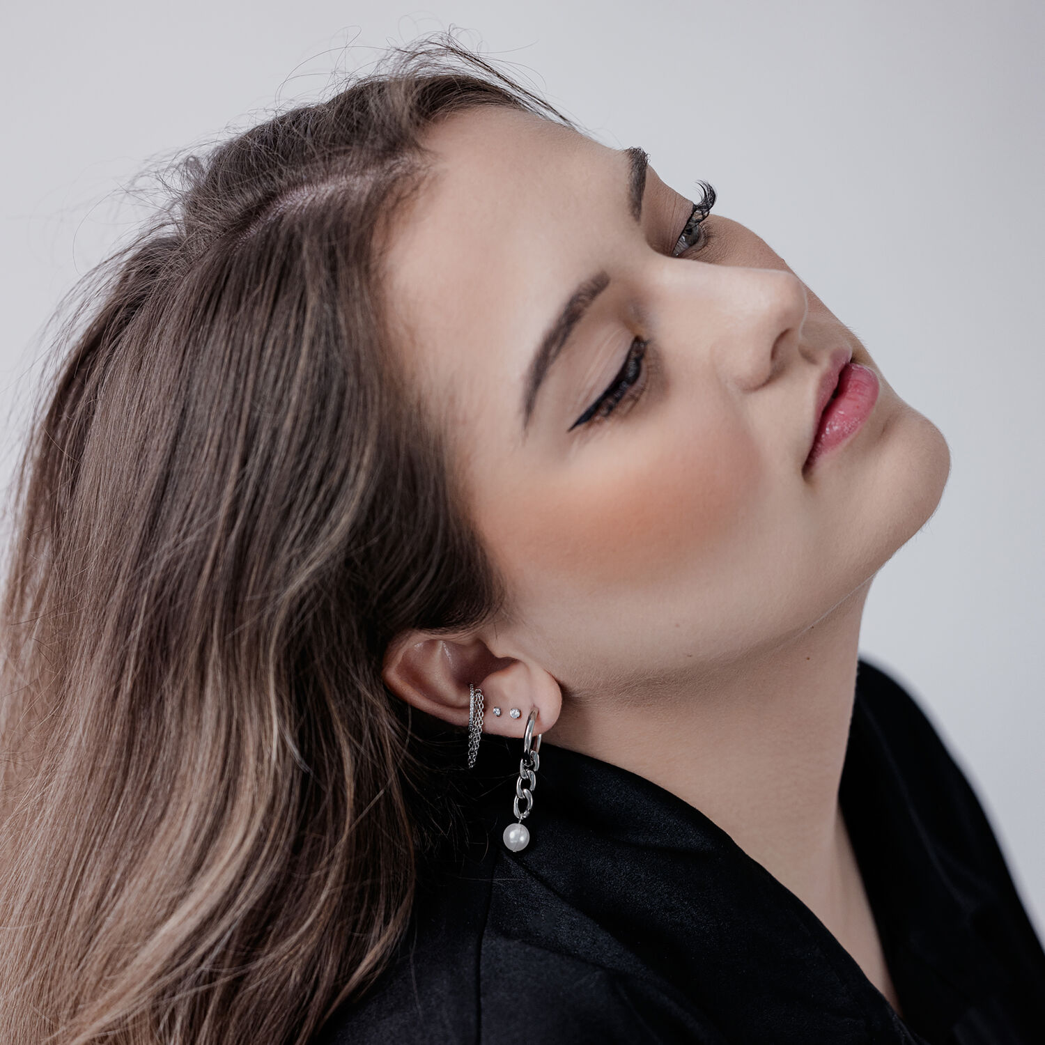 Femme avec un piercing Clicker Triple Chaîne en Cristal à l'oreille, sur fond blanc