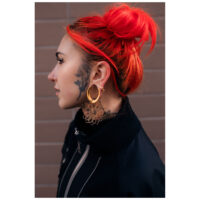 Kaleidoscope Hoops en or portés Femme aux cheveux roux portant des Kaleidoscope Hoops en or devant un mur de briques