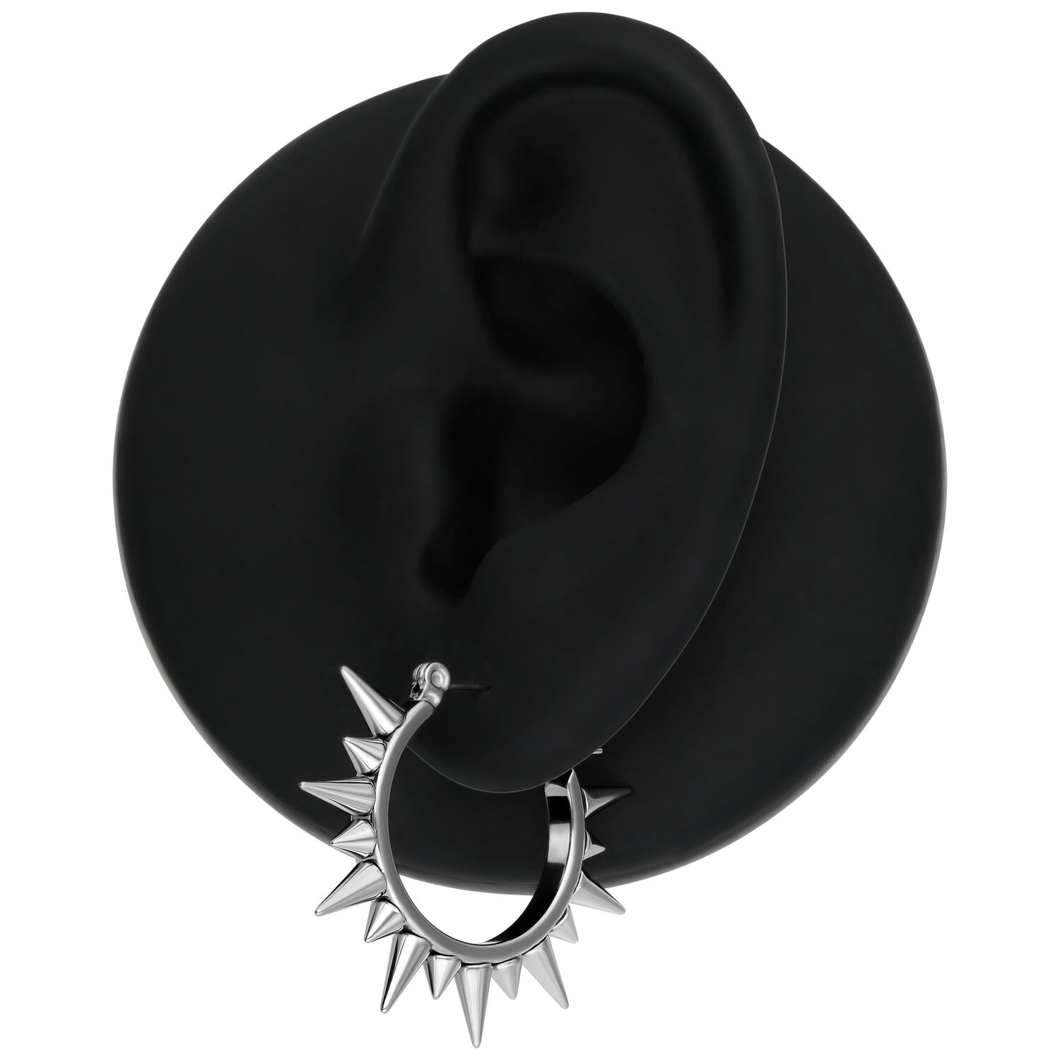 Boucles d'oreilles en argent à pointes sur un modèle d'oreille noir sur fond blanc