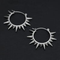 Deux boucles d'oreilles à pointes en acier chirurgical argenté sur fond noir