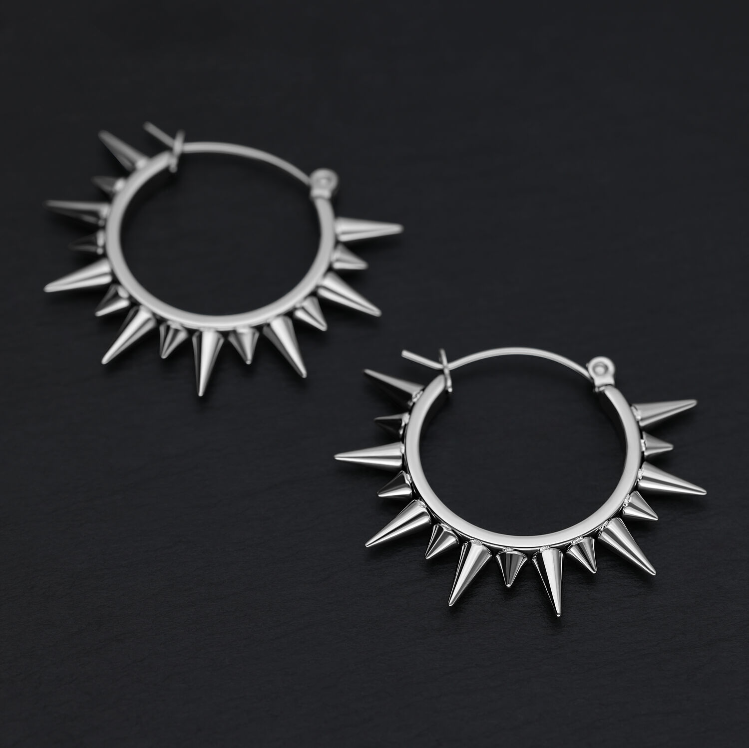 Deux boucles d'oreilles à pointes en acier chirurgical argenté sur fond noir