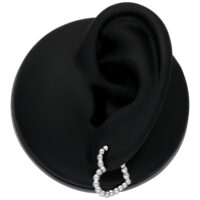 Créoles Bubble en forme de cœur en acier chirurgical Créole Bubble en forme de cœur argentée sur un modèle d'oreille noir sur fond blanc