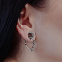 Boucles d'oreilles Bubble Polygon en argent à l'oreille Boucles d'oreilles Bubble Polygon en argent à l'oreille d'une personne