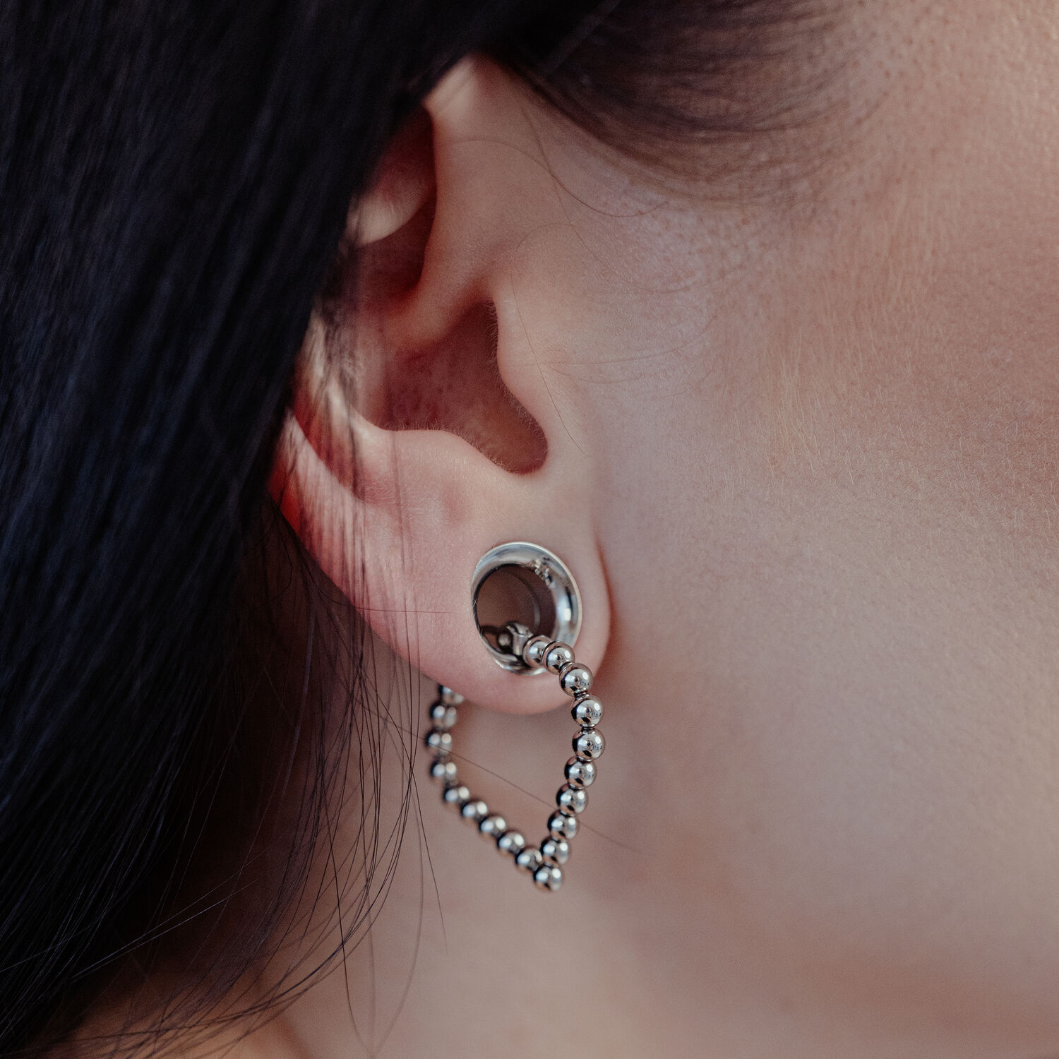 Boucles d'oreilles Bubble Polygon en argent à l'oreille Boucles d'oreilles Bubble Polygon en argent à l'oreille d'une personne