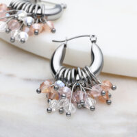 Boucles d'oreilles Glamour Hoops en argent avec cristaux Boucles d'oreilles Glamour Hoops en argent avec cristaux colorés sur fond marbré