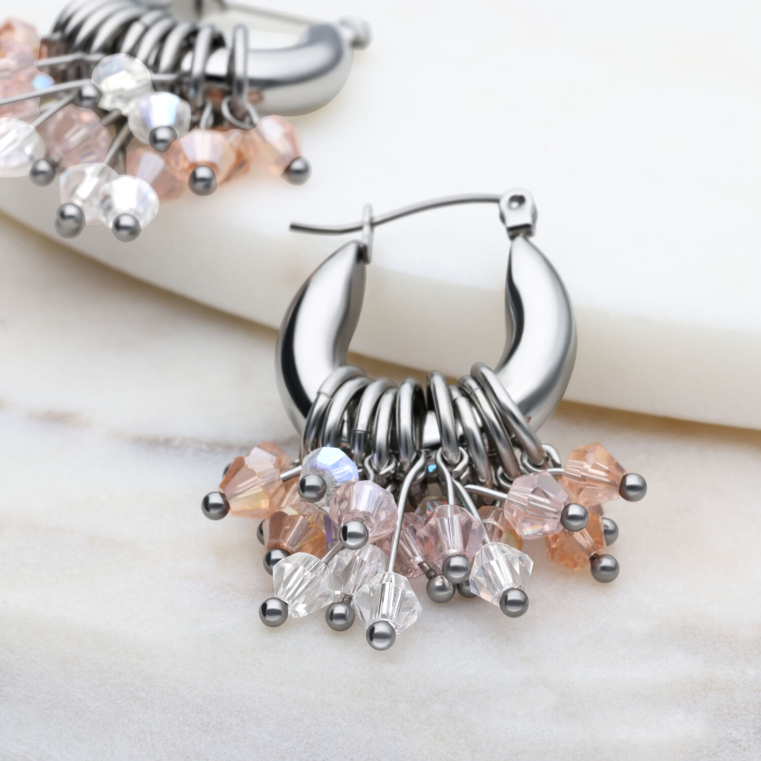 Boucles d'oreilles Glamour Hoops en argent avec cristaux Boucles d'oreilles Glamour Hoops en argent avec cristaux colorés sur fond marbré